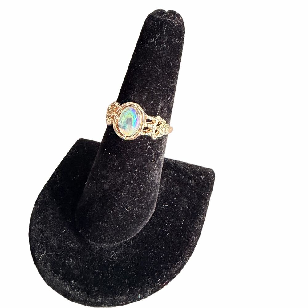 Iridescent elegant jewel on a gold tone ring band - around size 7.25